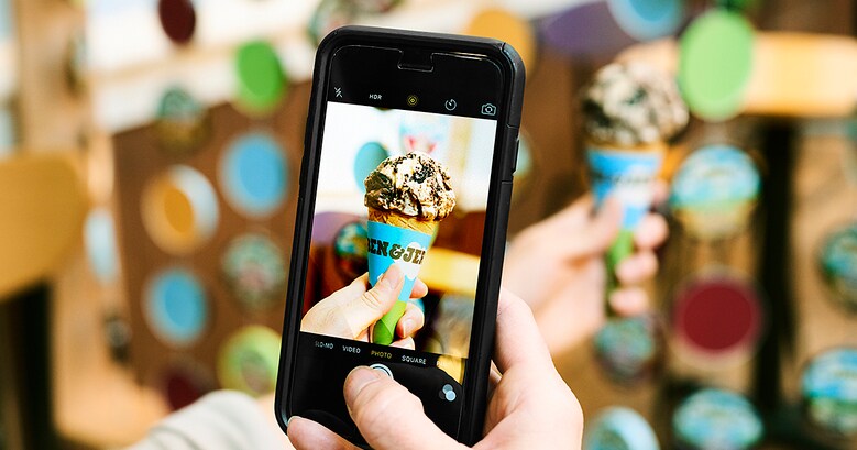 en hand håller en mobiltelefon